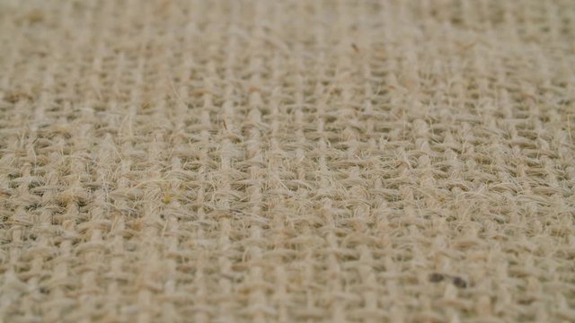 Extreme close up - coarse burlap of rare weave. . Texture, textile background. Macro shooting, camera slowly moving along the cloth on slider