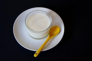 Glass of homemade yogurt on black background. Healthy breakfast concept.
