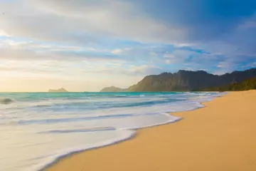 Fototapeten Coastline with waves at sunrise on the beach at Waimanalo on the windward side of Oahu in Hawaii © Ryan Tishken