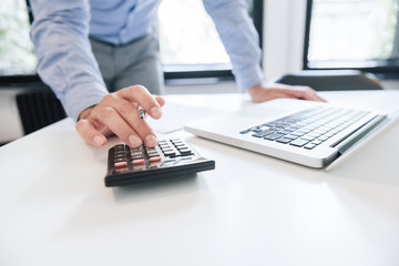 Close up businessman accountant hand holding pen working on calculator financial expert analyze business report finance corporate office with data analyzing accounting accountancy document laptop