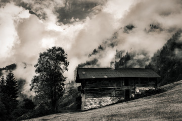 Fototapeta na wymiar Mystisches altes Bauernhaus im Nebel und Wolken