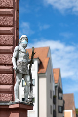 Obraz premium Statue mit Mundschutz an Hausgiebel