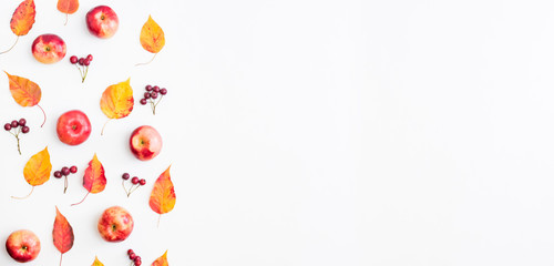 Flat lay pattern with colorful autumn leaves and apples on a white background