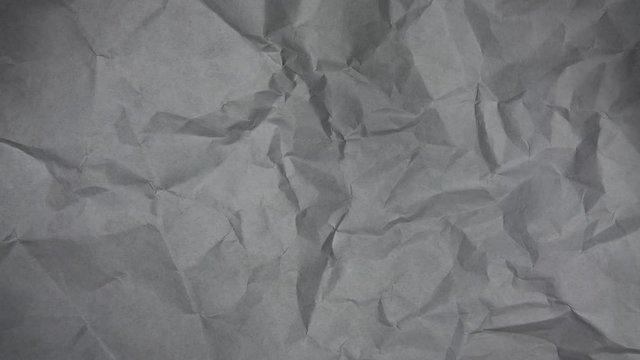 Stop motion animation. Crumpled grey paper texture background.