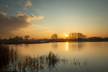 A beautiful sunset on a quiet lake with reeds