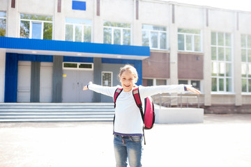 Happy school girl near   entrance to   school.