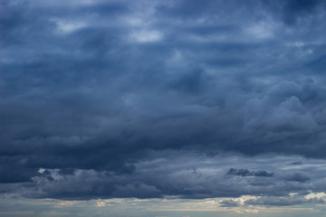 Obraz premium Cloudscape with blue heavy clouds on the sky. Cloudy sky with dark blue heavy clouds. Dark blue dramatic sky background.