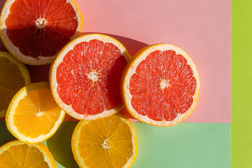 Creative background made of summer tropical fruits, grapefruit, orange, tangerine on pastel background. Citrus Food concept. Flat lay, top view, copy space.Creative layout