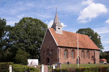 Fototapeta na wymiar Reformed Church from the 13th century in Zweeloo, once drawn by Vincent van Gogh. The drawing is in front of the church on wooden posts behind a fence