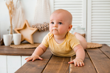 Cute toddler in the wooden kitchen of the house