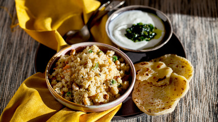 South Indian breakfast savory vegetable semolina porridge Rava Upma with green mint chutney and paratha.Authentic vegetarian food still life.