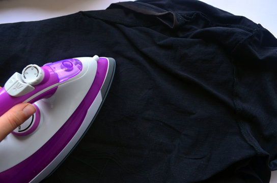 ironing. Pink-white iron on the background of things.