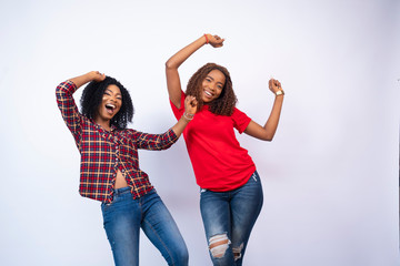 Obraz premium two beautiful young black women feeling excited and celebrating