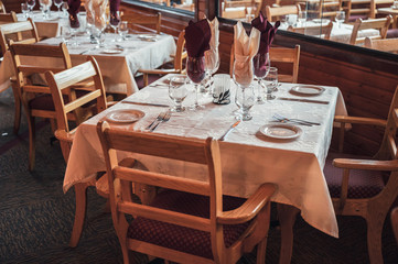 Rustic style of wooden dining table with tableware, glassware and napery