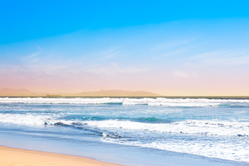 Blue ocean waves and yellow sand
