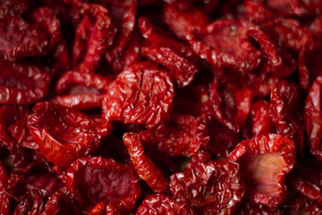 Close-up sun-dried tomatoes with spices and olive oil, background or concept, selective focus