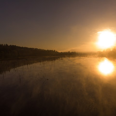 Sunrise or sunset on the lake with fog and steam