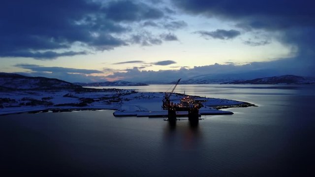 Cinematic aerial of arctic circle midnight sunset of oil rig platform