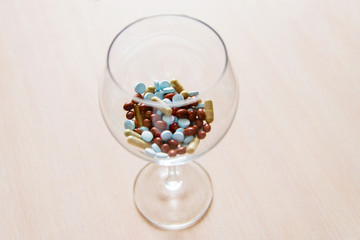 Pills in a glass bowl on a beige background