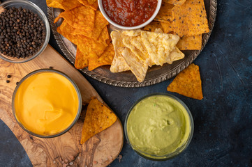 Snacks and different types of chips with dip, salsa, top view, rest and snacks for beer