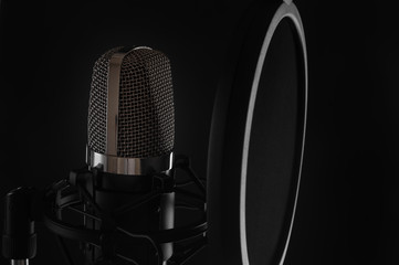 Black studio microphone on black background, close up