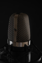 Black studio microphone on black background, close up