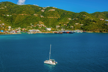 A catamaran sails gracefully towards Road Town Marina in Tortola