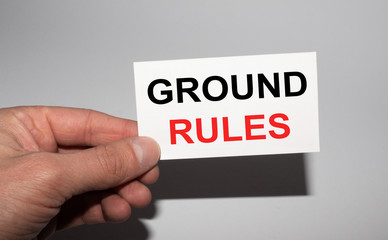 Message on the card GROUND RULES, in hands of businessman.