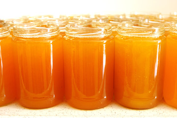 Front close-up of a bunch of flower honey in jars without lid