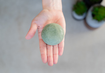 Hand holding solid shampoo bar