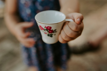 Fototapeta na wymiar Little girl holding old vintage coffee cup