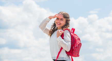 Outdoors classes. Successful schoolgirl. Good day for studying. Free education. Little child smiling going to school. Knowledge day. Happy girl with school backpack sky background. Back to school