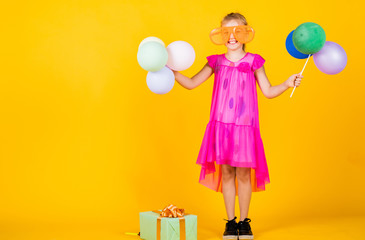 nice holiday party. kid having fun. international childrens day. happy childhood. little child with balloons. Entertainment birthday concept. child having party with balloons and gift box