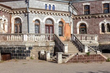 An old open outer stone staircase. Stone, cement steps of the old staircase with traces of weathering and destruction. An ancient stone staircase, ancient broken worn steps. Selective focus