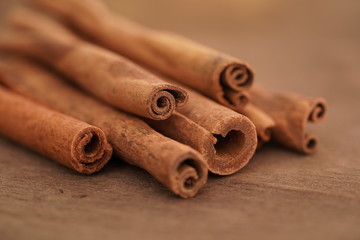 Selective focus, macro photo of cinnamon sticks on wooden brown background.Christmas time.Culinary spice for baking