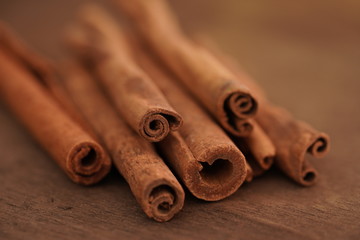 Selective focus, macro photo of cinnamon sticks on wooden brown background.Christmas time.Culinary spice for baking