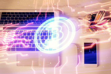 Blockchain theme hologram drawings over computer on the desktop background. Top view. Multi...