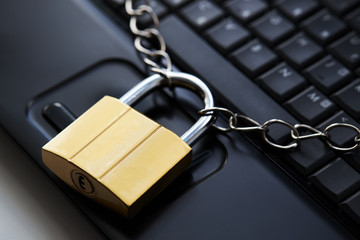 golden padlock on a black laptop keyboard over white background. internet security concept....