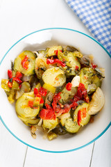 Steamed green zucchini dish on white background.