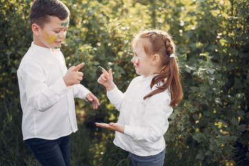 Beautiful little girl in a white shirt. Childred playing in a summer field