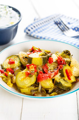 Steamed green zucchini dish on white background.