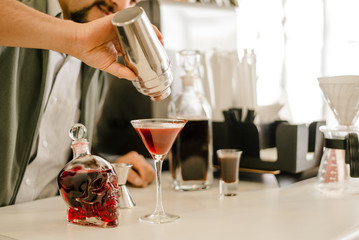 Barman preparando un cóctel rojo 