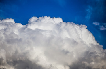Fluffy clouds cover the summer blue sky