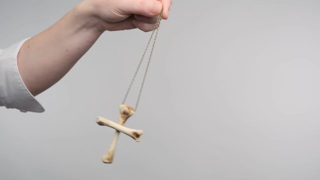 hypnotic pendulum sways in female hand of hypnotist during hypnosis session.