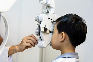 optometrists are examining pediatric patients' eyes with the Autorefractor