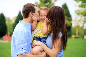 Portrait of a happy family in the summer outdoors in the park