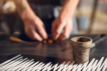 A person takes tobacco. The person is preparing a hookah. There is a table.