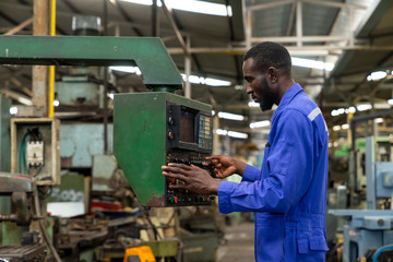 Fototapeta na wymiar African american industry worker control machines in the workplace on a business day. Technician engineer checking and working in the factory. Concept of Industrial manufacturing.