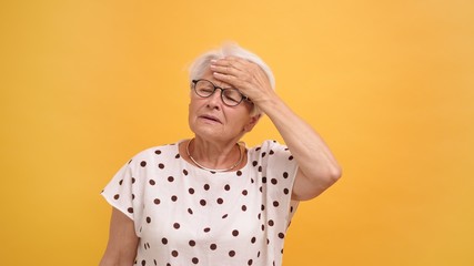 senior woman having a strong headache. Putting hand over her forehead. High quality photo