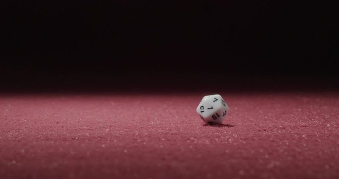 Wide of White 20-Sided Dice Rolling in Slow Motion Revealing Several Sides